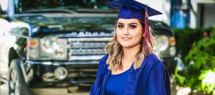 Young woman wearing graduation cap and gown.